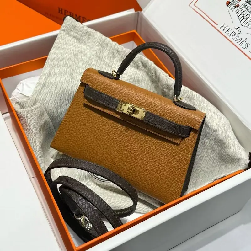 Replica Hermes Kelly 19cm bag in Gold Epsom leather with palladium hardware on marble surface