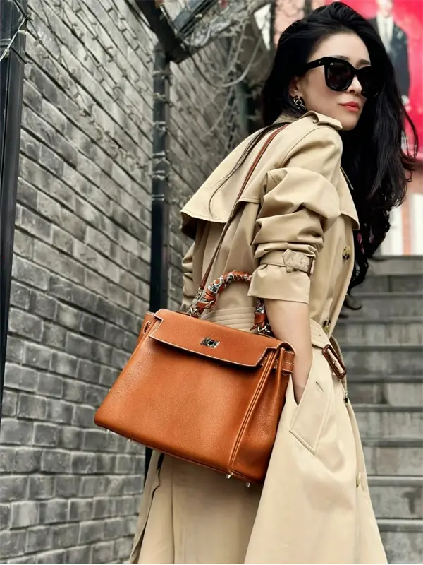 Replica Kelly 32cm Top Handle Carry: Office to Evening Elegance Close-up of replica Hermes Kelly 32cm Gold top handle carry with blazer outfit