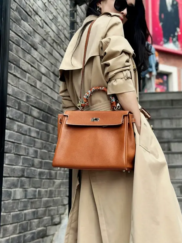 How to Style Replica Gold Kelly 32cm: Casual Shoulder Carry Woman wearing replica Hermes Kelly 32cm Gold bag with shoulder strap in city streets