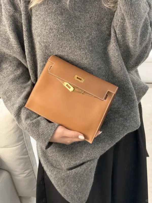 Close-up of hand carrying Golden Brown Hermes Kelly Danse replica as clutch