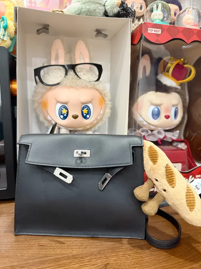 Capacity demonstration: Black Hermes Kelly Danse replica holding full-size wallet, phone and makeup pouch