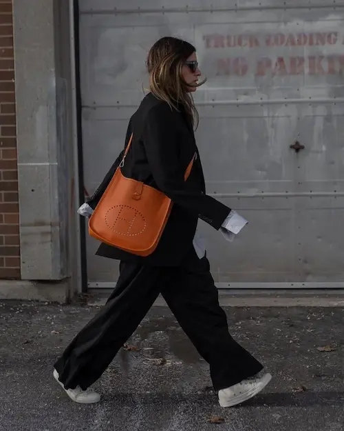 Bold Orange Evelyne 29 Replica Statement Vibrant Orange Hermes Evelyne 29 replica bag worn crossbody in urban setting